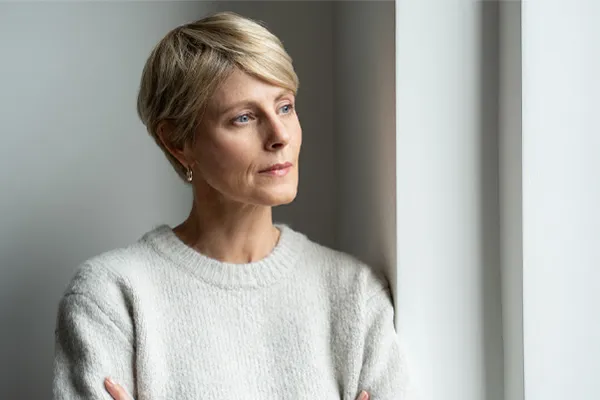 Chronic-Fatigue-Therapy A blond, middle-aged woman looks out the window with a tired expression. Get chronic fatigue treatment from Better Life Carolinas of Mount Pleasant in Charleston Metro.