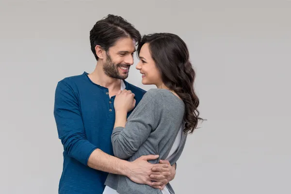 Erectile-Dysfunction-Doctor A man in a blue shirt embracing a woman in a gray shirt smiles due to his successful erectile dysfunction care from Better Life Carolinas of Mount Pleasant in Charleston Metro.