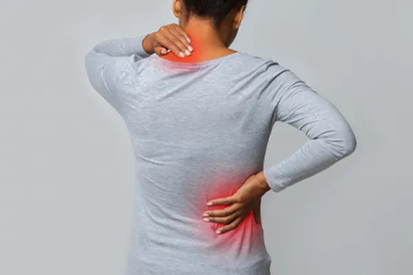 Fibromyalgia-Clinic An image from behind of a woman suffering from Fibromyalgia holding her hands on her neck and lower back. Get fibromyalgia care from Better Life Carolinas of Mount Pleasant in Charleston Metro.