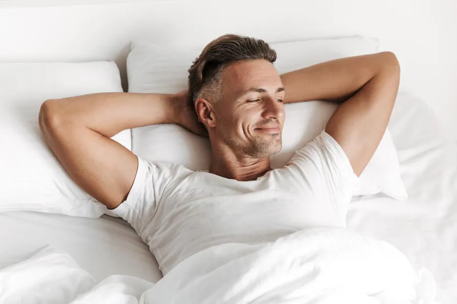 Peyronies-Disease-Clinic A contented man sits in bed smiling. Schedule GAINSwave treatment for Peyronie's Disease from Better Life Carolinas of Mount Pleasant in Charleston Metro